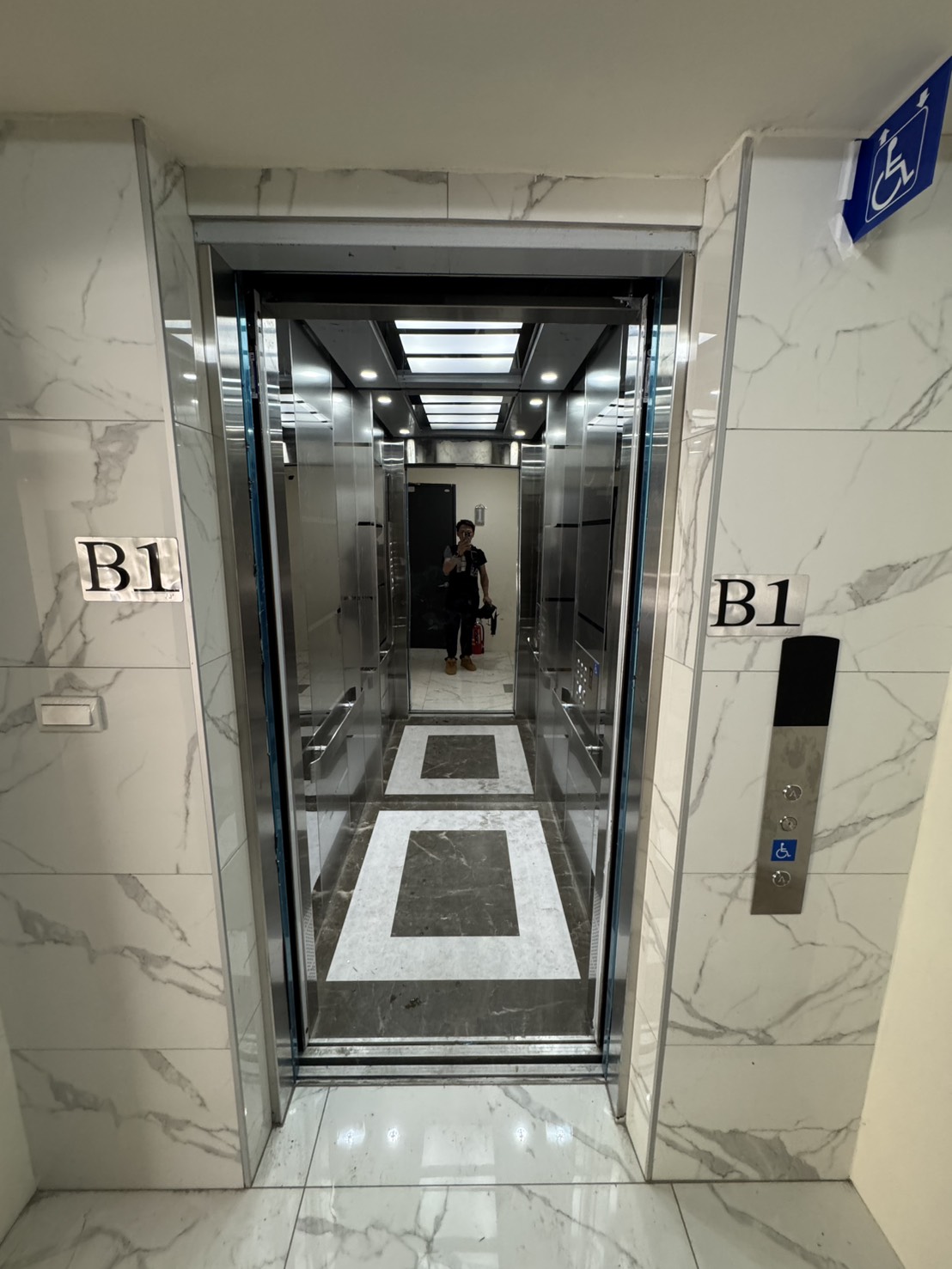 鑫豐富建設 B1 無障礙標示旁的電梯門廳與開啟車廂