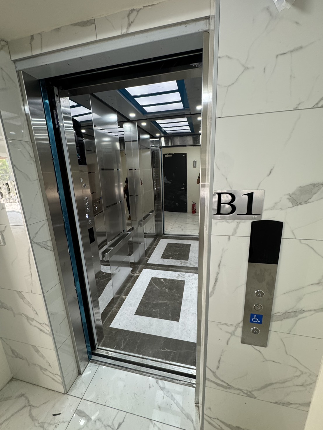 鑫豐富建設 B1 門廳中開啟的電梯車廂與無障礙操作面板